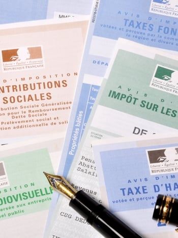 Auto-entrepreneur à son bureau complétant sa déclaration initiale de CFE en ligne